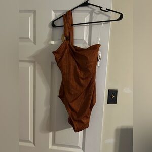 women swimsuit in rust with metallic gold lines through the entire swimsuit.
